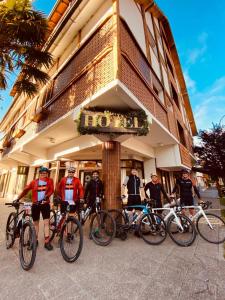 um grupo de pessoas em pé em frente a um edifício com suas bicicletas em Tunqueley Hotel em San Martín de los Andes