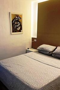 1 dormitorio con 1 cama y una pintura en la pared en Casa Bruna Beach House, en Playa del Inglés