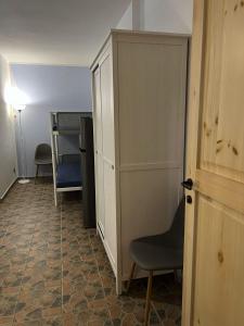 a room with a chair and a cabinet and a table at Agriturismo Graziano e Barbara in Porto Conte