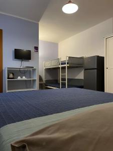 a room with a bed and a bunk bed and a tv at Agriturismo Graziano e Barbara in Porto Conte