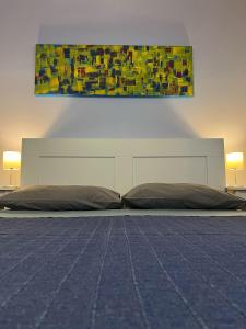 a bedroom with a bed and a painting on the wall at Agriturismo Graziano e Barbara in Porto Conte