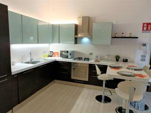 een keuken met groene kasten en een wit aanrecht bij Bareggio Comfort Apartment in Bareggio