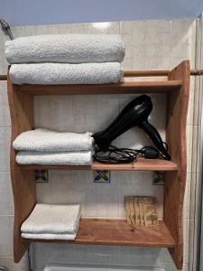 a wooden shelf with towels and a black phone on it at Agriturismo Graziano e Barbara in Porto Conte