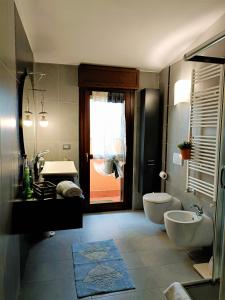 een badkamer met 2 wastafels, een toilet en een deur bij Bareggio Comfort Apartment in Bareggio