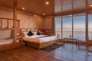 a bedroom with a bed and a view of the mountains at JK Dream View Kufri in Kūfrī
