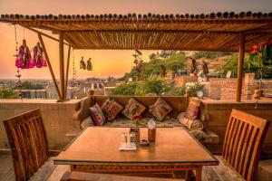 een tafel en een bank op een patio met uitzicht bij Hotel The Silk Route in Jaisalmer