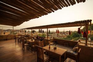 un restaurant avec des tables et des chaises et une vue sur la ville dans l'établissement Hotel The Silk Route, à Jaisalmer