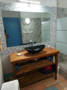 La salle de bains est pourvue d'un lavabo et d'un miroir. dans l'établissement Appartements Residence Mahoghany, à Sainte-Anne