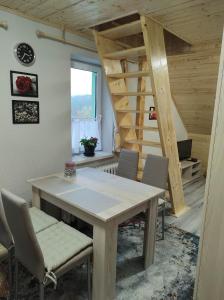 una mesa y sillas en una habitación con escalera en U Berňáků en Abertamy