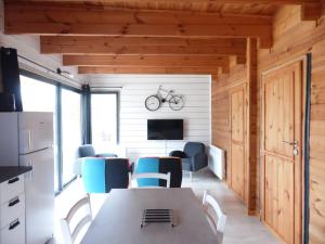a dining room with a table and chairs and a tv at Chalet cosy climatisé avec parking et Internet in Doué-la-Fontaine