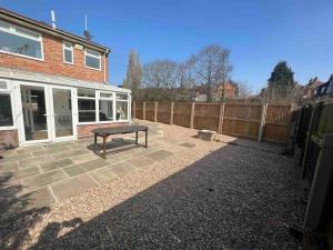 a patio with a bench in front of a fence at Wye Gardens 3 bedroom home with parking and garden in Nottingham