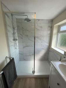 a shower with a glass door in a bathroom at Wye Gardens 3 bedroom home with parking and garden in Nottingham