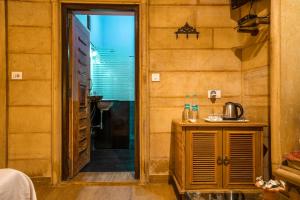 Habitación con una puerta que conduce a una habitación con cocina. en Hotel The Silk Route en Jaisalmer