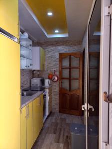 a small kitchen with yellow cabinets and a door at Le Loft 32 in Dakar +7 photos