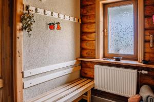 a wooden room with a bench and a window at Brīvdienu māja ''Rātes'' Valmiermuiža in Valmiermuiža