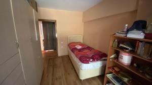 ein kleines Schlafzimmer mit einem Bett und einem Bücherregal in der Unterkunft Feel the nature near to Viaport marina in Tuzla