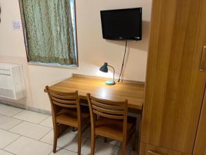 einem Holztisch mit 2 Stühlen und einem TV in der Unterkunft HOTEL MARE PINETA in Bari