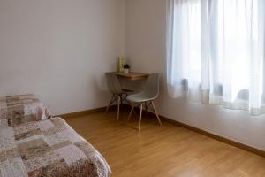 sypialnia ze stołem, łóżkiem i oknem w obiekcie Hostal L'Estació w mieście Puigcerdà