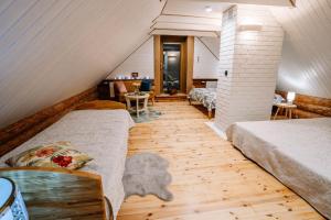 a attic room with two beds and a table at Brīvdienu māja ''Rātes'' Valmiermuiža in Valmiermuiža