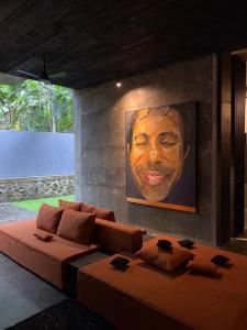 a living room with a large couch and a painting at Saffron Robes Living in Hikkaduwa