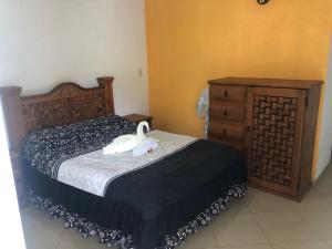 Un dormitorio con una cama con un pato blanco. en Los Robles, en Tepoztlán