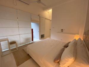 a white bedroom with a bed and a chair at Saffron Robes Living in Hikkaduwa