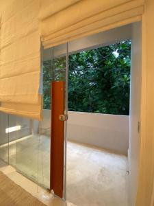 a room with a glass door and a window at Saffron Robes Living in Hikkaduwa