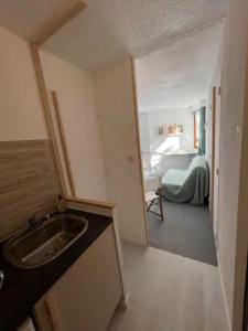 a bathroom with a sink and a room with a bed at Modern studio in the heart of the station 1650 in Les Orres