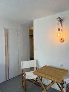 a dining room with a table and a white chair at Modern studio in the heart of the station 1650 in Les Orres