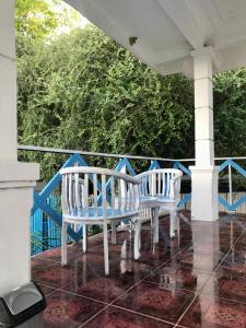 Duas cadeiras brancas sentadas num alpendre em The House Hostel em Gili Trawangan