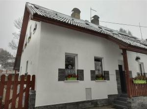 uma casa branca com duas janelas e uma cerca em U Berňáků em Abertamy