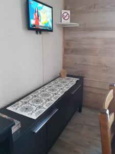 a bed in a room with a tv on a wall at Studio pied des pistes 4 personnes in Les Deux Alpes