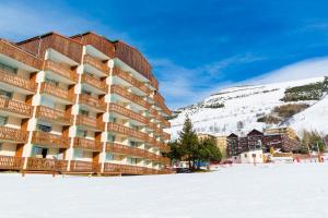a hotel in the snow in front of a mountain at Studio pied des pistes 4 personnes in Les Deux Alpes