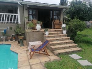 a patio with a chair next to a swimming pool at Protea Private Suite - Ramsgate Ramble Rest in Margate