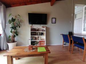 ein Wohnzimmer mit einem Tisch und einem TV an der Wand in der Unterkunft Protea Private Suite - Ramsgate Ramble Rest in Margate