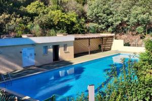 une grande piscine bleue avec un bâtiment dans l'établissement chambre lit 2 personnes dans appartement du logeur, à Mandelieu-la-Napoule