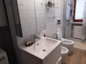 a white bathroom with a sink and a toilet at Einaudi 9 in Bardonecchia