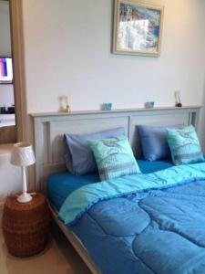 1 dormitorio con 1 cama con sábanas azules y lámpara en Chelona Hua Hin, en Khao Tao