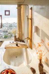 a bathroom with a tub with two glasses of wine at Cherry Suites Dalat in Da Lat