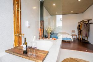 a bathroom with a bottle of wine and glasses on a counter at Cherry Suites Dalat in Da Lat