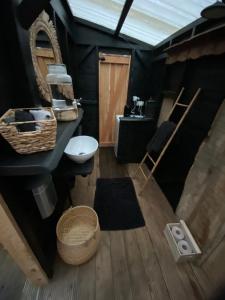 a bathroom with black walls and a sink and a mirror at Home Sweet Dôme in Bouillon in Noirefontaine