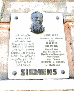 een teken met een buste van een vrouw aan de muur bij Siemens House in Tbilisi City