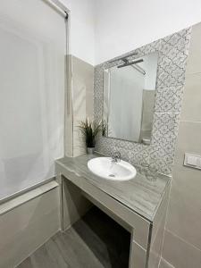 a bathroom with a sink and a mirror at Pensión Bienvenido in Seville