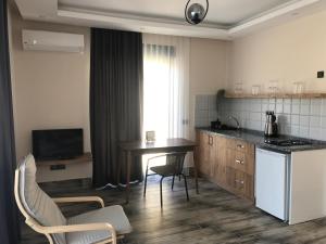a kitchen with a table and chairs in a room at Tanem Suit in Kemer