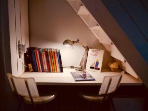 una scrivania con lampada, libri e sedie di Chambre et salon sur la Loire à vélo a Les Ponts-de-Cé