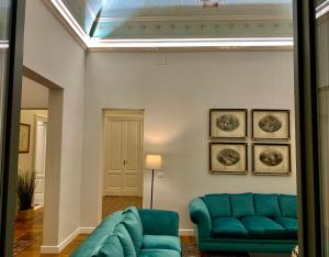 a living room with a blue couch and a ceiling at La Renaissance in Catania
