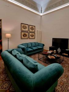 a living room with two blue couches and a television at La Renaissance in Catania