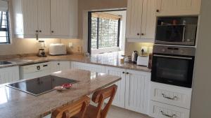 a kitchen with white cabinets and a granite counter top at Sea Escape in Sea Park