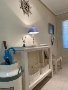 een tafel met een lamp in een kamer bij Residencial Vistamar in Santoña