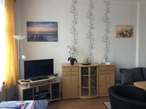 a living room with a flat screen tv and a entertainment center at Ferienwohnung Sprenger _ Objekt 25 in Rostock